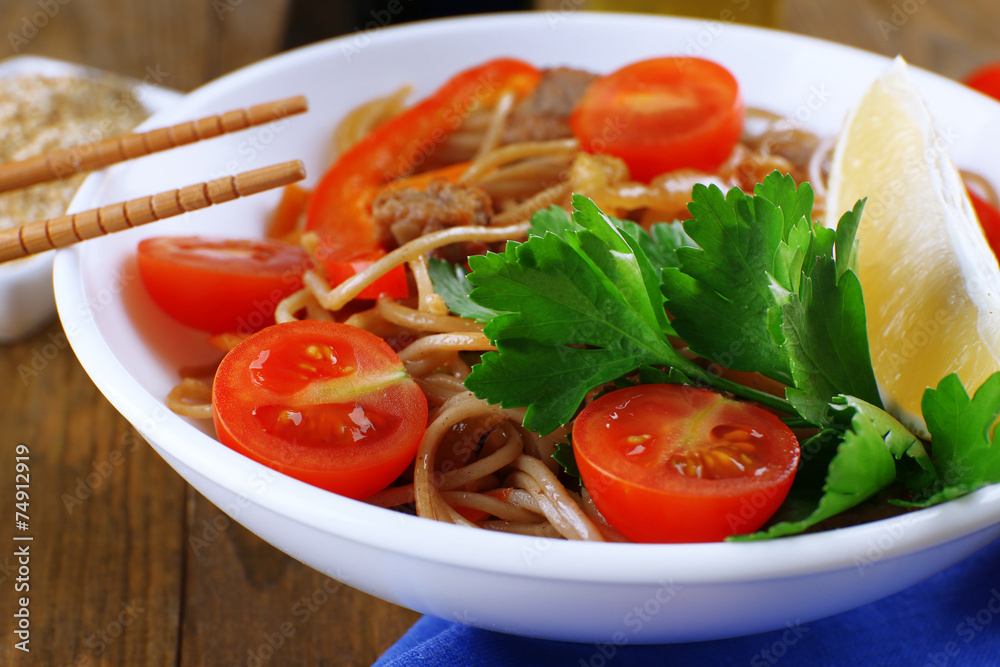 Chinese noodles with vegetables and roasted meat in bowl