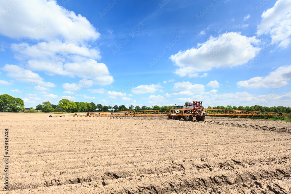 Fototapeta premium Tractor on a cultivated field in the countryside
