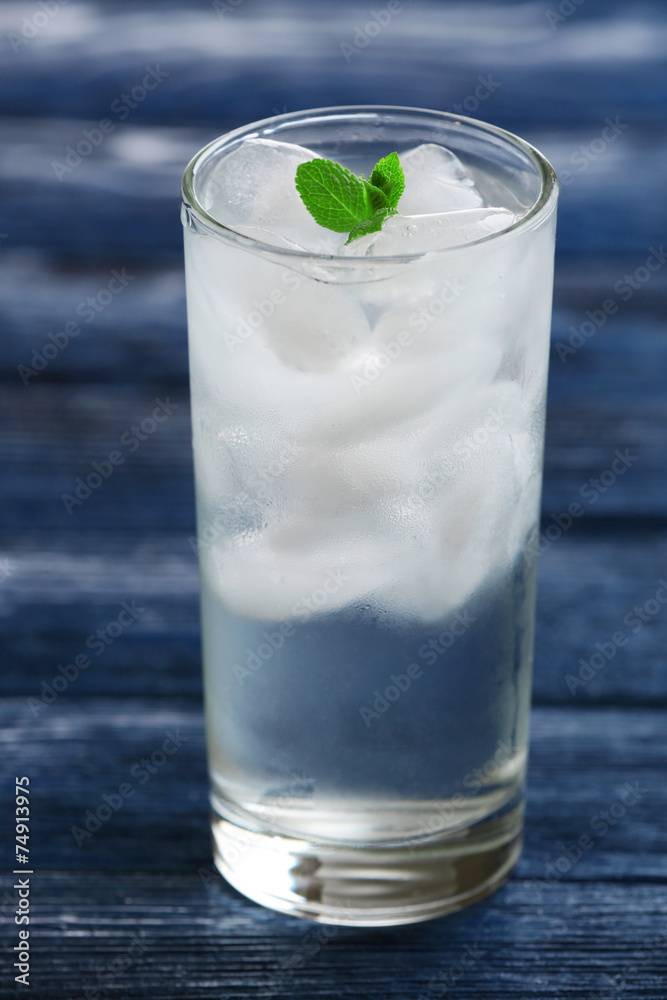 Glass with ice cubes on wooden table Glass with ice cubes on wooden table