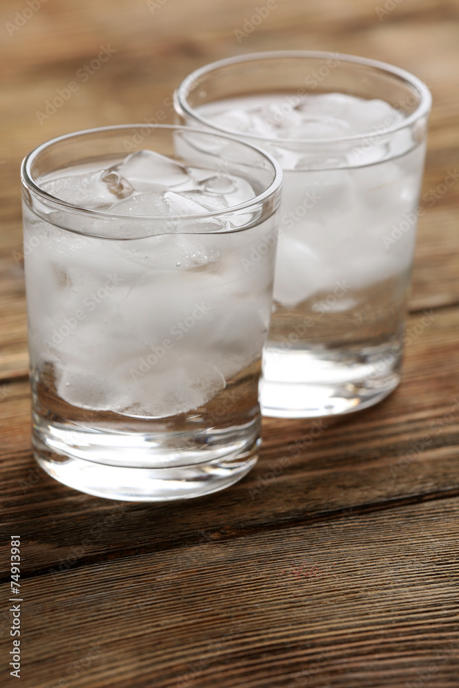 Glasses with ice cubes on wooden table Glasses with ice cubes on wooden table