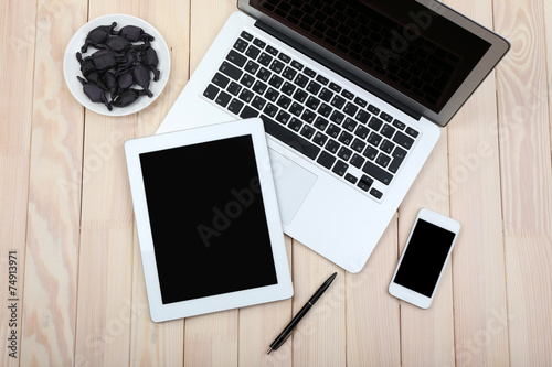 Open notebook, digital tablet and smart phone with saucer of