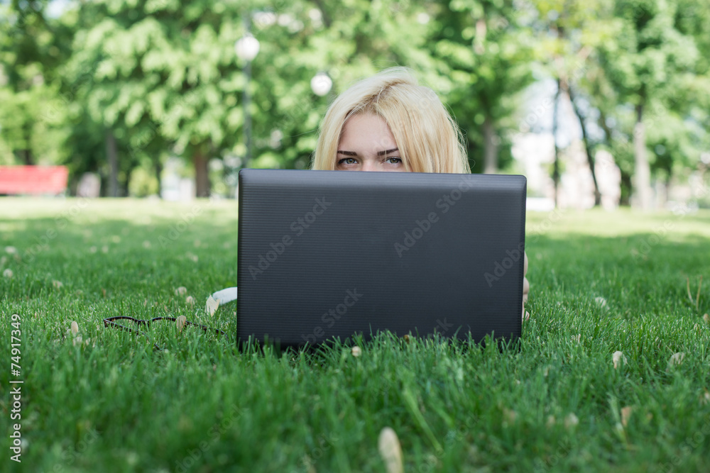 Young woman hiding behind a laptop Young woman hiding behind a laptop