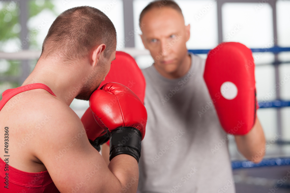 boxer and his coach doing some sparring in ring. boxer and his coach doing some sparring in ring.