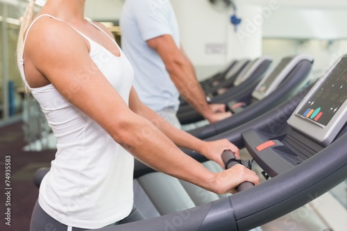 Side view mid section of couple running on treadmills at gym © WavebreakmediaMicro
