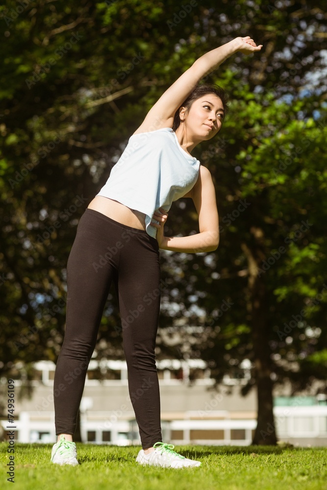 Healthy woman doing stretching exercises in park Healthy woman doing stretching exercises in park