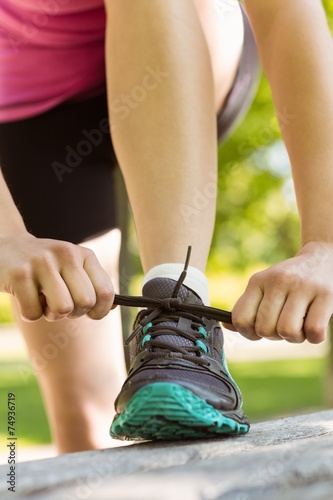 Fit woman tying her shoelace
