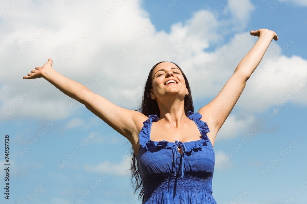 Smiling brunette in blue dress feeling free Smiling brunette in blue dress feeling free