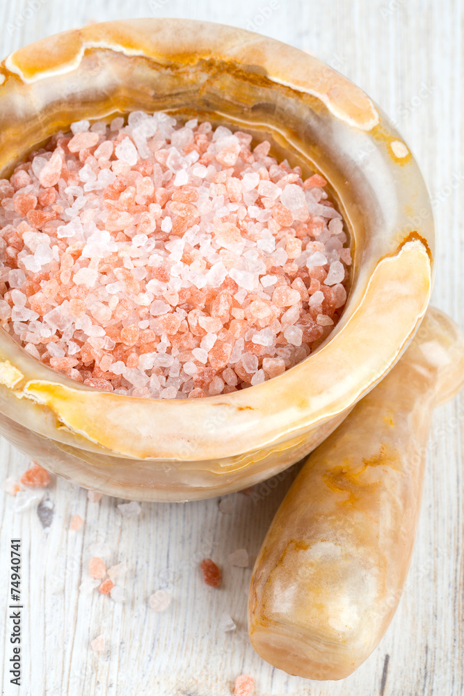 pink himalayan salt in a mortar on wooden surface pink himalayan salt in a mortar on wooden surface