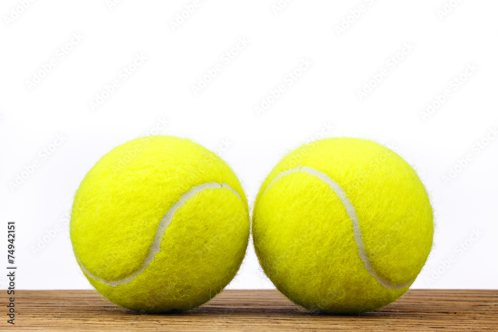 Two tennis balls table wood isolated