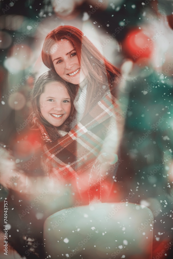 Composite image of festive mother and daughter wrapped in blanke Composite image of festive mother and daughter wrapped in blanke