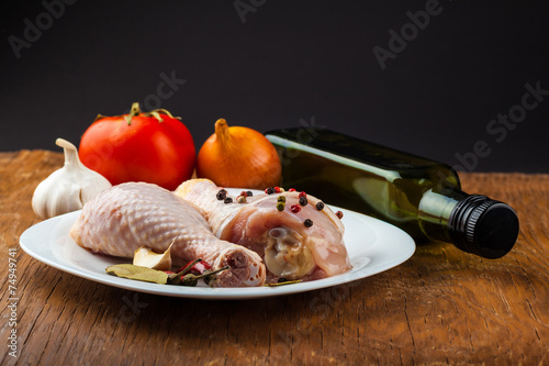 raw chicken legs on wooden board with spices