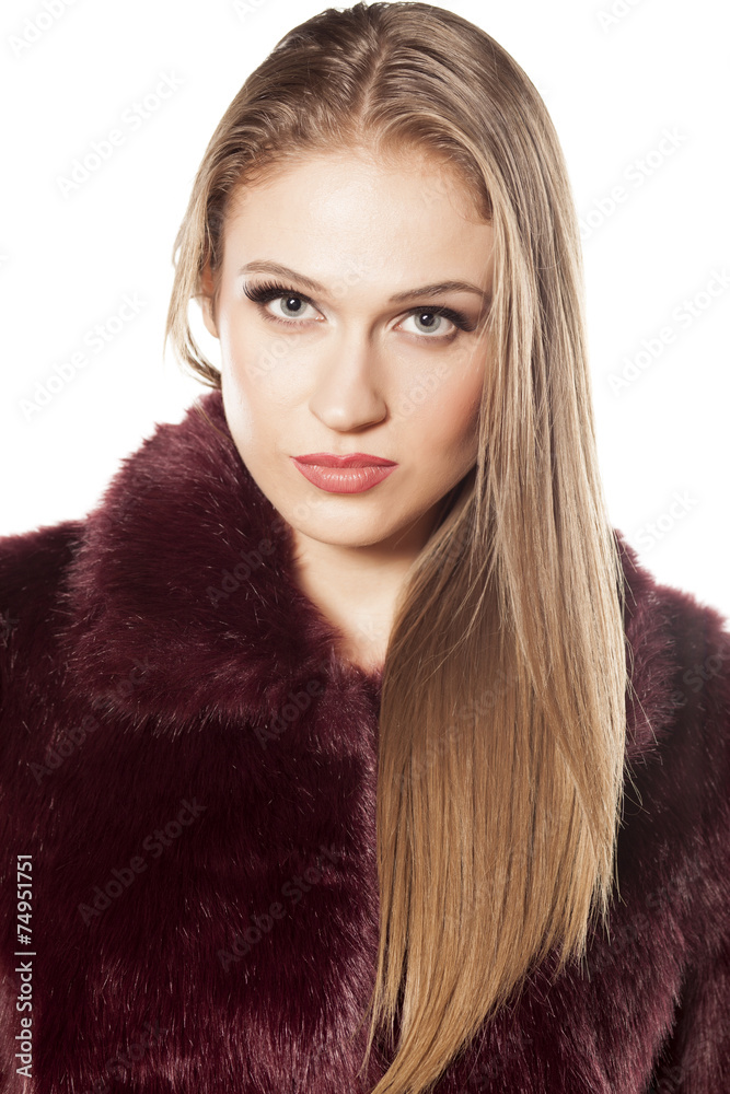 serious beautiful blonde in fur coat on a white background serious beautiful blonde in fur coat on a white background