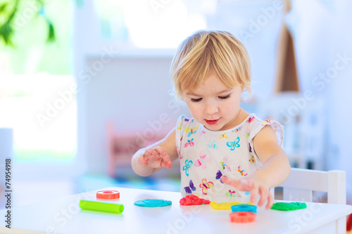 Preschooler girl playing with plasticine