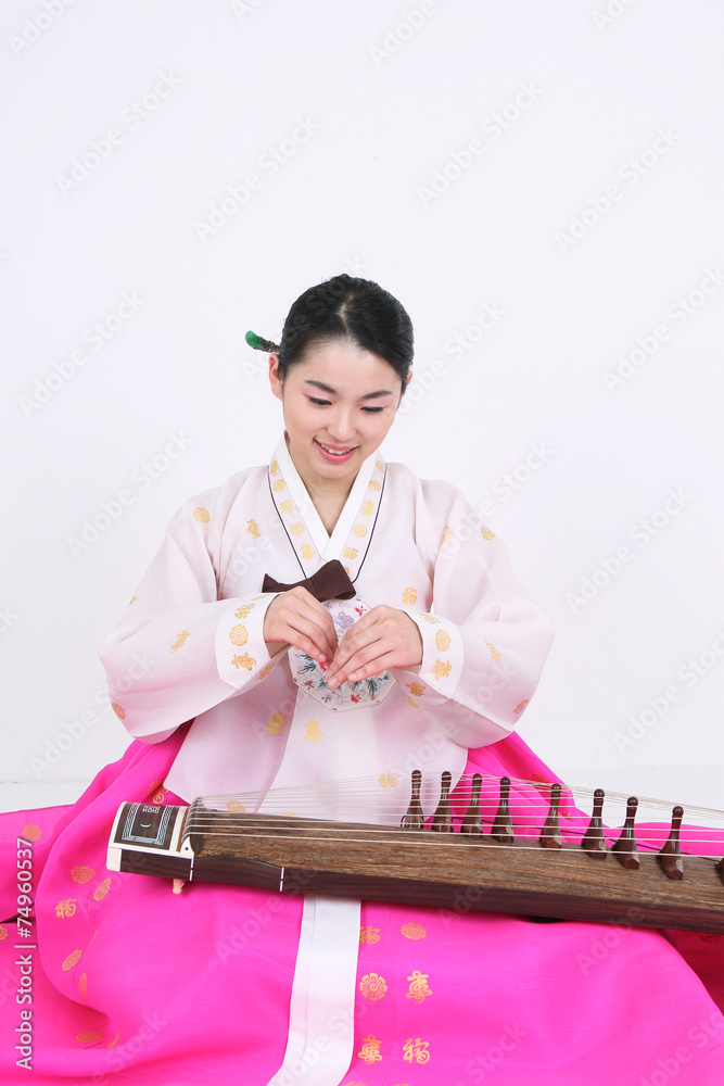 가야금을 뜯는 한복 입은 여성