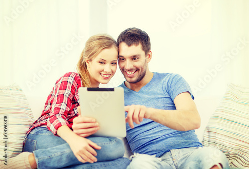 smiling couple with tablet pc computer at home © Syda Productions