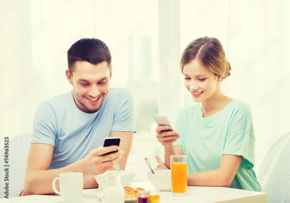 smiling couple with smartphones reading news smiling couple with smartphones reading news