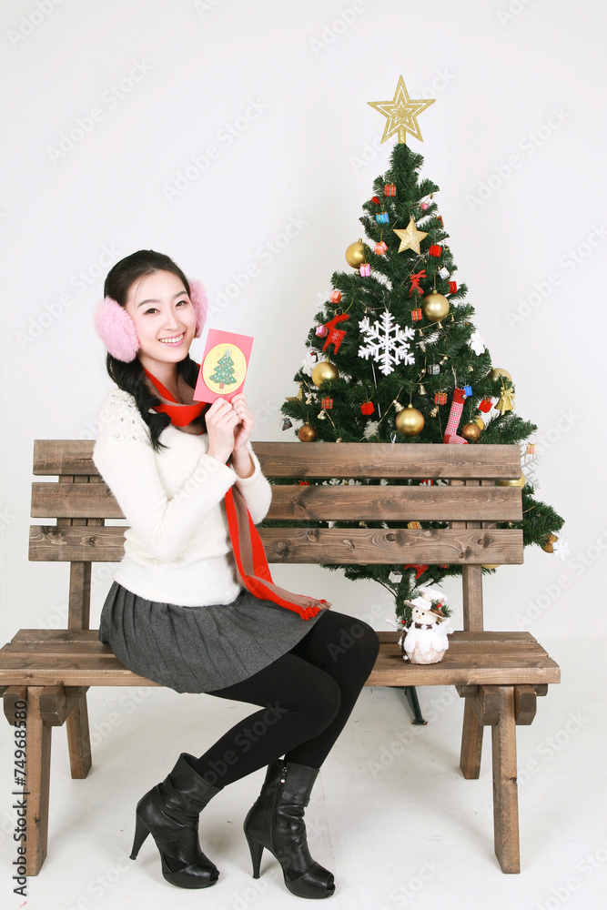 크리스마스 트리 옆의 젊은 한국 여성