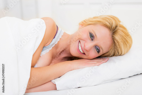 Young attractive blonde woman sleeping in a bed
