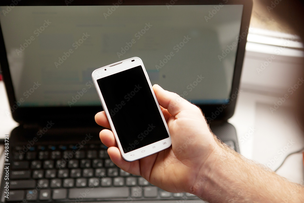 Man using smartphone, close-up, notebook on the background Man using smartphone, close-up, notebook on the background
