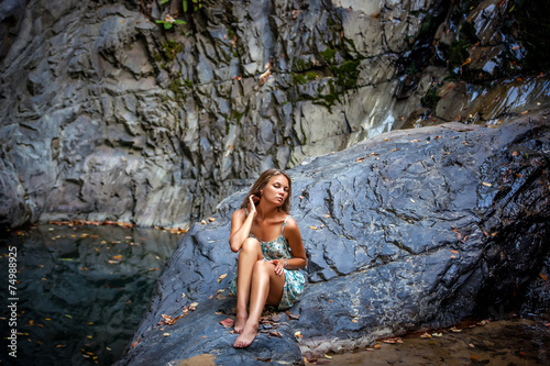 beautiful girl posing in dress at the waterfall