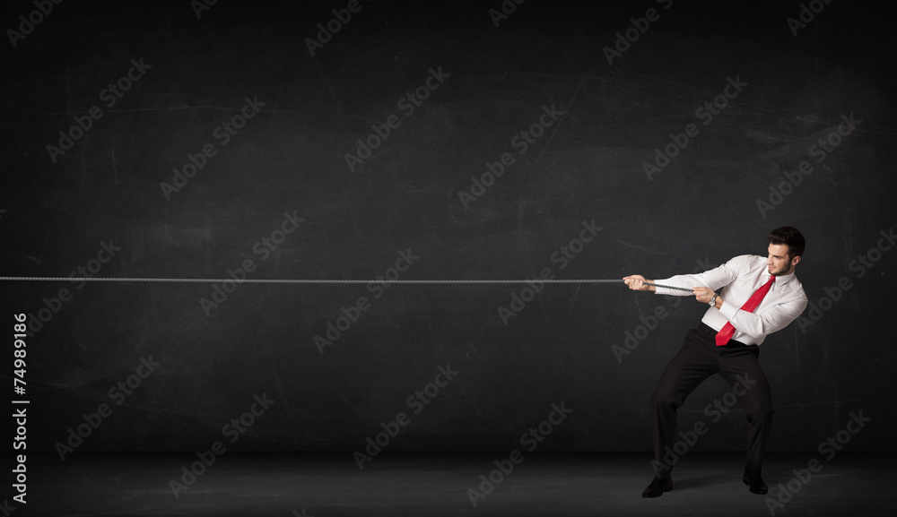 Businessman pulling rope on grey background