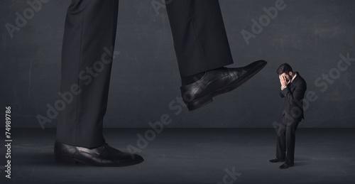 Giant person stepping on a little businessman concept