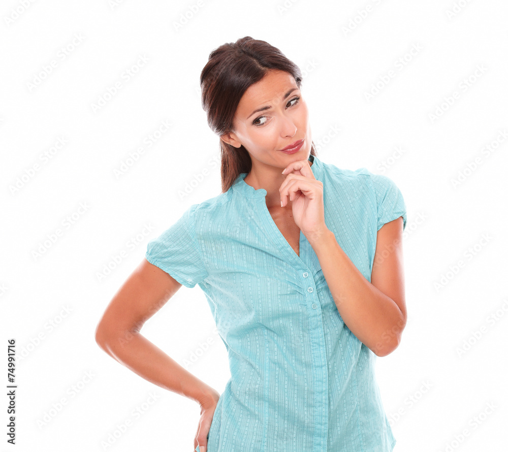 Girl in blue shirt holding chin and wondering Girl in blue shirt holding chin and wondering
