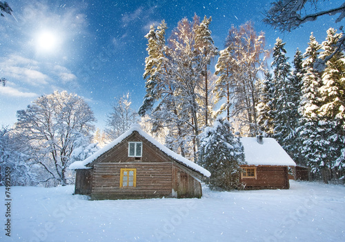Old houses in snowy forest