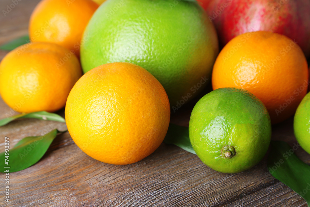 Ripe citrus with green leaves on wooden background Ripe citrus with green leaves on wooden background