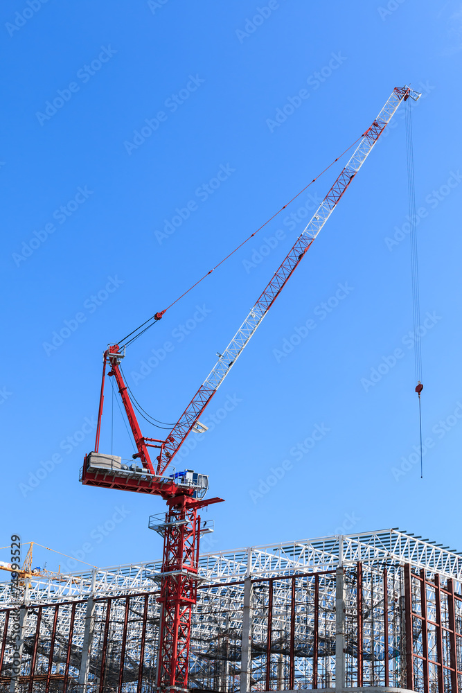 Crane at construction site against blue sky