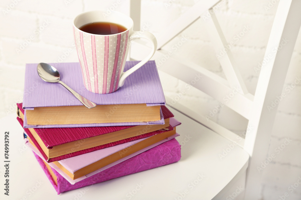 Naklejka premium Pile of books with cup and spoon