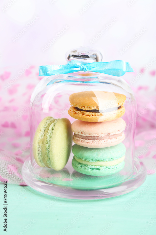 Gentle colorful macaroons in glass bell jar and milk glass Gentle colorful macaroons in glass bell jar and milk glass