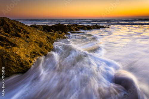 Rocks and waves in the Atlantic Ocean at sunrise in Palm Coast,