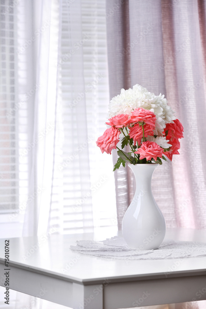 Fototapeta premium Beautiful flowers in vase with light from window
