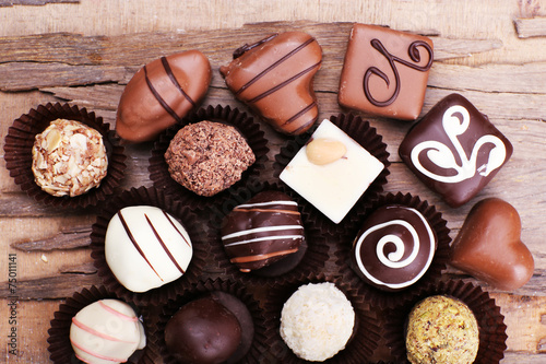 Many chocolates on wooden textured background