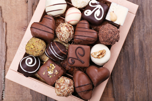 Box filled with chocolates on wooden rustic background