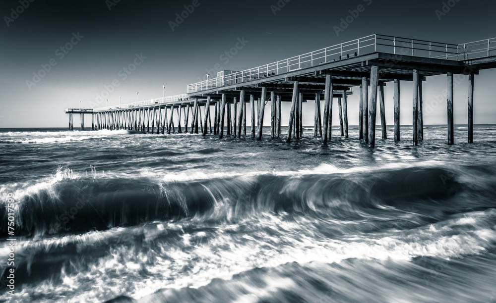 A fishing pier and waves in the Atlantic Ocean at sunrise, in Ve