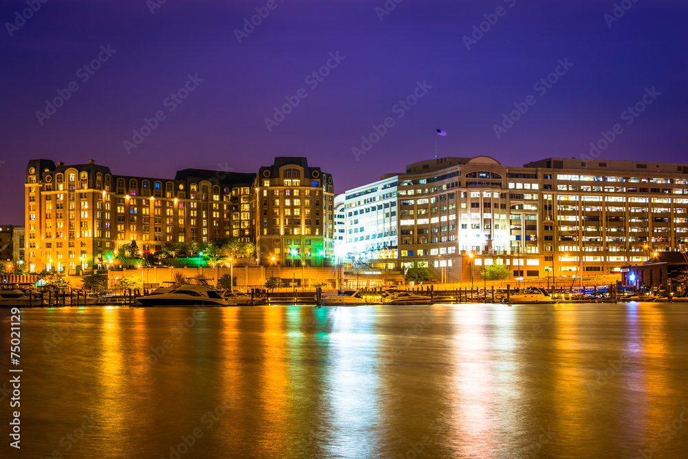 Buildings along the waterfront at night in Washington, DC.
