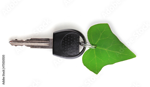 Car key with green leaf trinket isolated on white photo