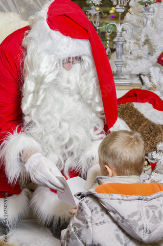 Santa taking child's letter of wishes and reading them