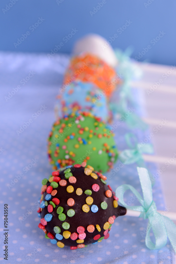 Sweet cake pops on table on blue background