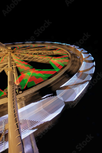 Fairground ferris wheel with colorful light trails