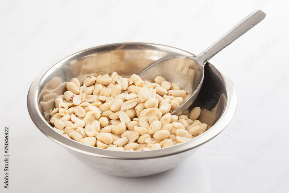 Peeled peanuts in bowl with transfer scoop Peeled peanuts in bowl with transfer scoop