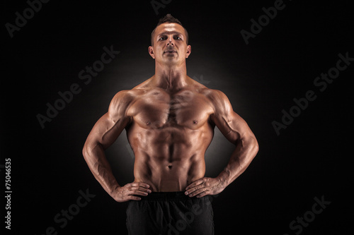 Muscular man on black background © bondarchik