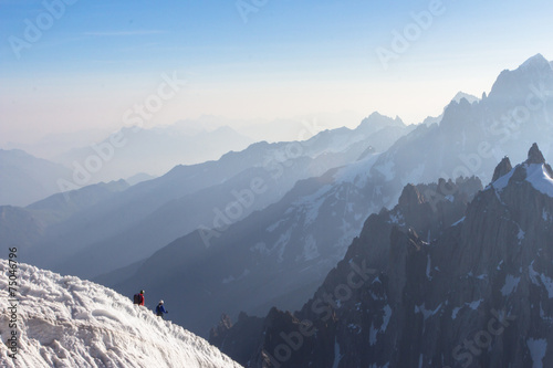 Mont Blanc mountaneers walking on snowy ridge.  photo