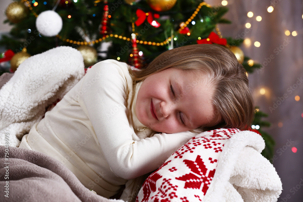 Little girl sleeping on Christmas tree background Little girl sleeping on Christmas tree background