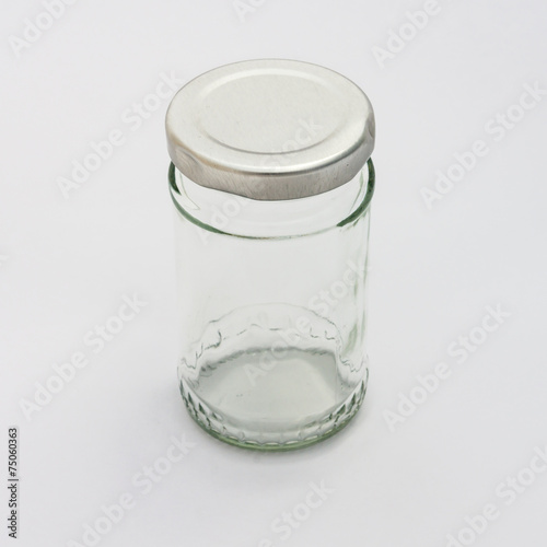 Glass bottle with silver lid isolated on white background