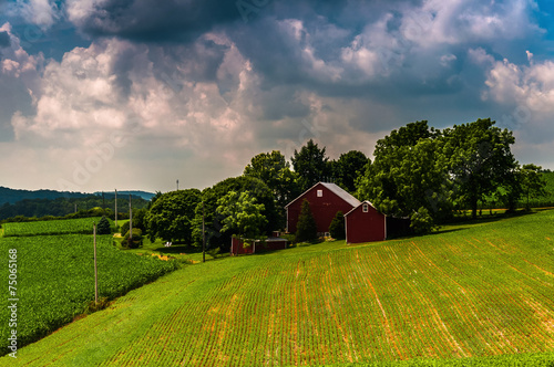 Dark clouds over a barn and farm fields in rural Southern York C