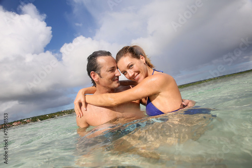 Cheerful middle-aged couple embracing in the sea