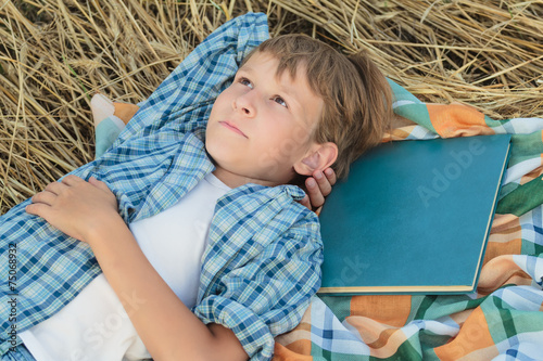 Fotografie Teenage boy dreaming inspired by book